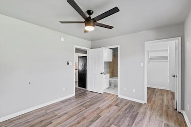 Unfurnished bedroom featuring a closet, light woo