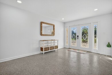 Entryway featuring french doors, recessed lighting, and speckled floor