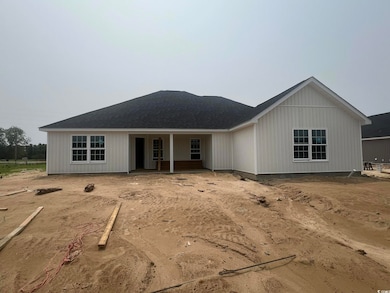 View of front of house featuring roof with shingles, uncovered parking, and covered porch