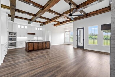 Kitchen with dark wood-type flooring, coffered cei