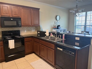 Kitchen with black appliances, a peninsula, orname
