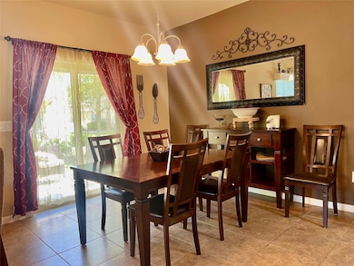 Tiled dining room featuring a notable chandelier 