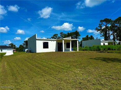 Back of property featuring stucco siding and a law