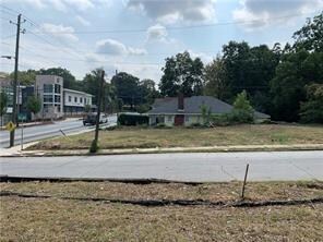 View of asphalt road featuring sidewalks and curbs