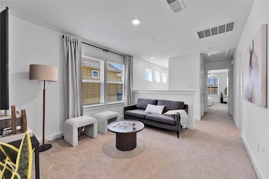 Living area featuring baseboards, attic access, visible vents, and carpet flooring