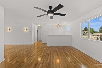 Unfurnished living room with a ceiling fan and wood finished floors