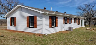 View of side of property with central AC and a law