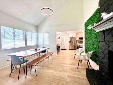 Dining space with high vaulted ceiling, light woo