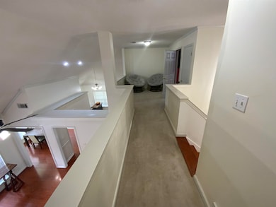 Hall featuring an upstairs landing and wood finished floors