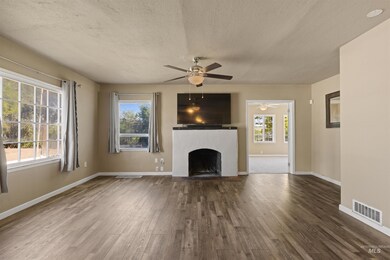Unfurnished living room with a textured ceiling, wood finished floors, and a fireplace