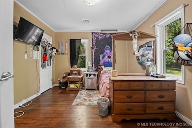 Bedroom featuring multiple windows, wood-type floo