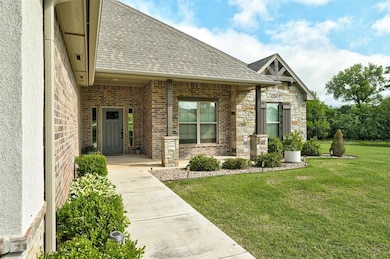Property entrance with roof with shingles, a yard,