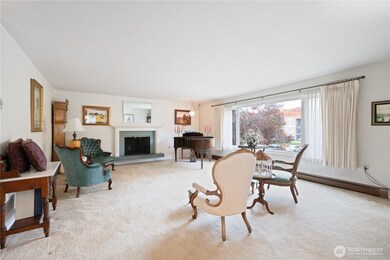 Oversized living room with fireplace and huge windows overlooking the park