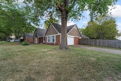View of front facade with driveway, brick siding, and a garage