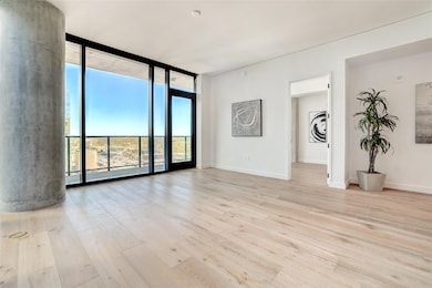 Spare room with a wall of windows and light wood-style floors
