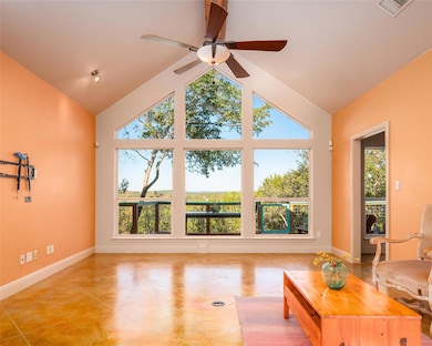 Tiled living area featuring a ceiling fan and hig