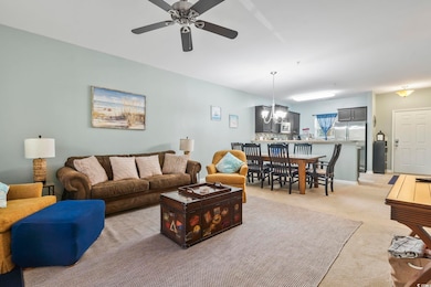 Living area featuring light carpet, ceiling fan wi