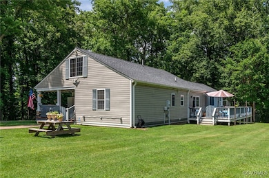 Back of house with a yard, a wooden deck, and view