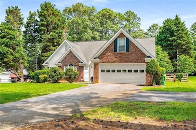Traditional home with driveway, brick siding, a front yard, and a shingled roof