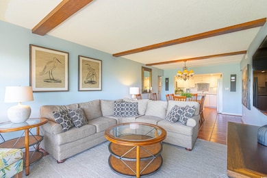 Living room with a chandelier and beamed ceiling