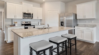 Kitchen featuring white cabinets, dark wood-type f