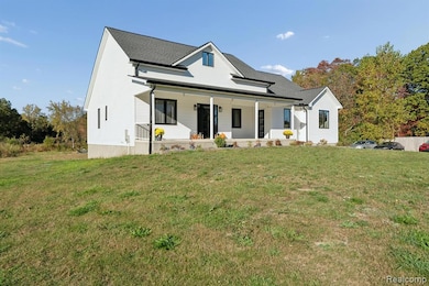 View of front of property featuring covered porch and a lawn