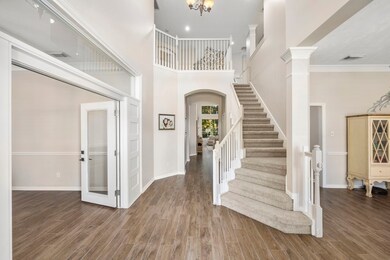 Inviting front porch opens into the two-story entry flanked by an office behind French doors and a formal dining room.
