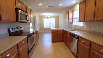 Large Kitchen with Pantry, lots of Cabinets, Stainless Steel Appliances, and a separate breakfast room overlooking private back yard..