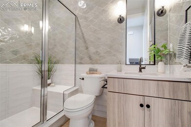 Bathroom featuring vanity, toilet, tile walls, and