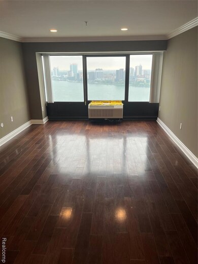 Spare room with crown molding, a city view, and dark wood-style floors