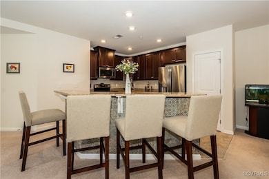 Kitchen featuring a kitchen bar, light stone count