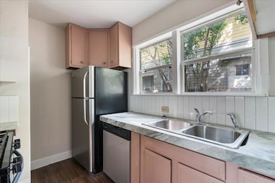 Kitchen with light countertops, dark wood-type fl