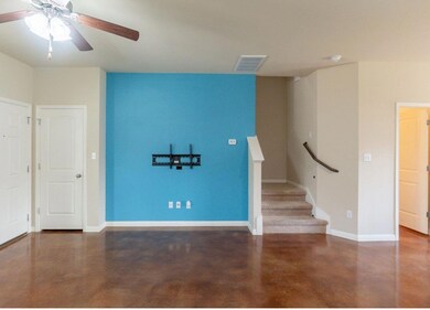 Unfurnished room featuring stairs, concrete floor