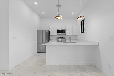 Kitchen with marble finish floor, appliances with