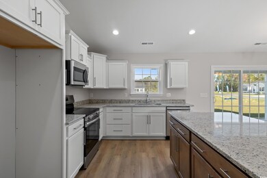 Kitchen with visible vents, a sink, white cabinets