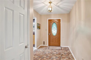 Foyer entrance featuring baseboards and stone finish flooring
