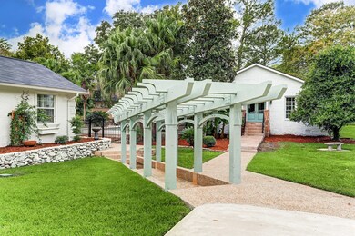 A beautiful custom pergola is situated between the main house and the guest cottage