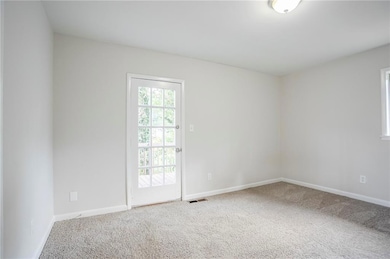 Carpeted empty room featuring baseboards