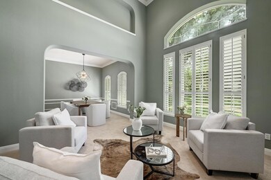 Beautiful crown molding and neutral paint tones create an elegant and timeless ambiance throughout the formal living room.