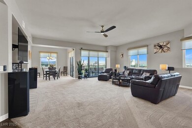 Living area featuring plenty of natural light, ceiling fan, and carpet floors