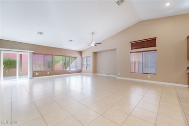 Unfurnished room with light tile patterned floors, high vaulted ceiling, plenty of natural light, and a ceiling fan