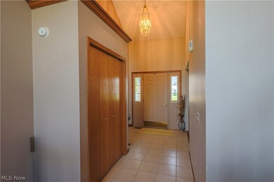 Tiled entrance foyer featuring a notable chandelier