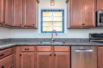 A closer look at the beautiful decorative window above the recessed kitchen sink.