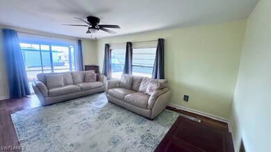 Living area featuring ceiling fan, wood finished f