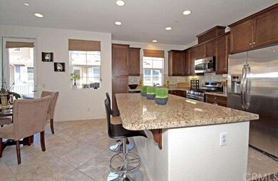 Kitchen features dark wood cabinetry, granite coun