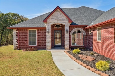 Entrance to property featuring brick siding, a yard, stone siding, and roof with shingles