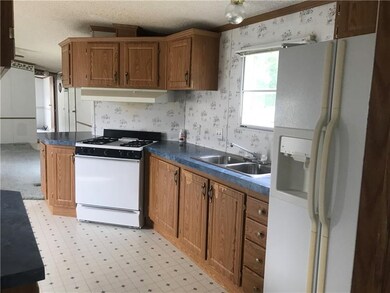 Opposite view of kitchen with refrigerator that ha