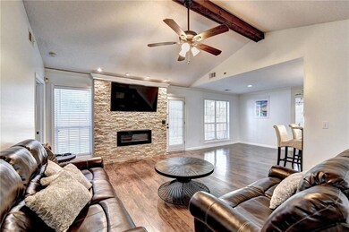 Living room featuring a ceiling fan, wood finished floors, a stone fireplace, and recessed lighting