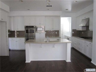 Gourmet kitchen with hardwood floors, island & gra