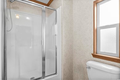 Full bath with a stall shower and toilet
